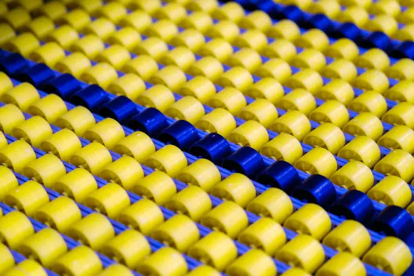 Endüstriyel tesisteki canlı sarı ve mavi taşıyıcıların tam çerçeve arkaplanı