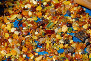 Piyasada tezgaha yerleştirilmiş çeşitli şekil ve boyutlarda kehribar taşlarından.