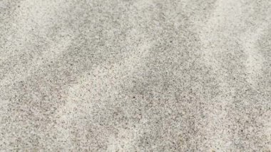 Sahilde kumsalın dalgalı zemininde gün ışığında hafif bir dalgalanma.