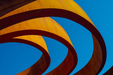 Çağdaş binanın dışından şehrin bulutsuz mavi gökyüzüne güneş ışığı yüzükleriyle çevrili.