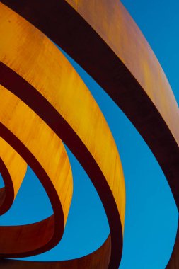 Çağdaş binanın dışından şehrin bulutsuz mavi gökyüzüne güneş ışığı yüzükleriyle çevrili.