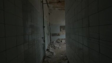 Duvarda kırık kiremitler ve açık pencereyle odaya girerken elde çekilen görüntü.