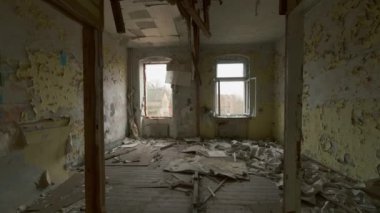 Karanlık, ürkütücü bir binada eski, terk edilmiş bir odayı gösteren el kamerası görüntüsü.
