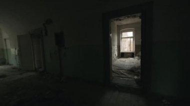Gün ışığında uzun ve karanlık bir koridorda ve terk edilmiş binaların odalarında yürürken elde çekilen görüntüler.