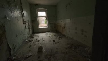 Gün ışığında uzun ve karanlık bir koridorda ve terk edilmiş binaların odalarında yürürken elde çekilen görüntüler.