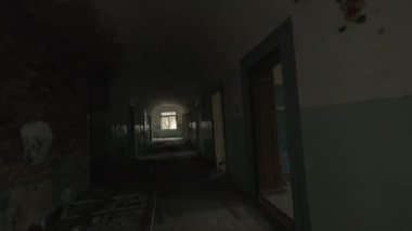 Gün ışığında uzun ve karanlık bir koridorda ve terk edilmiş binaların odalarında yürürken elde çekilen görüntüler.