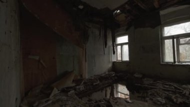 Handheld shot of walking inside of demolishing rooms on gloomy day in abandoned aged building