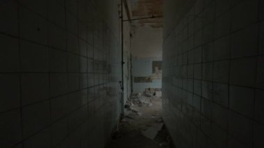 Duvarda kırık kiremitler ve açık pencereyle odaya girerken elde çekilen görüntü.