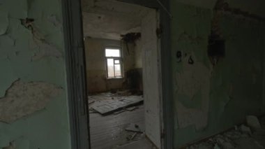 Terk edilmiş bir binada kasvetli bir günde yıkım odalarının içinde yürürken elde çekilmiş bir fotoğraf.