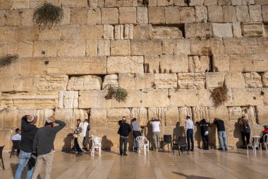 Tel Aviv, İsrail - 22 Kasım 2022: Kudüs 'te günlük ibadet geleneği sürerken, Batı Duvarı' na bakan Yahudi erkeklerin arka planı
