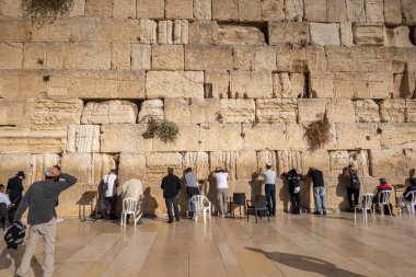 Tel Aviv, İsrail - 22 Kasım 2022: Kudüs 'te günlük ibadet geleneği sürerken, Batı Duvarı' na bakan Yahudi erkeklerin arka planı