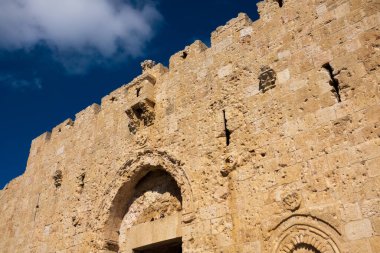 Eski Kudüs bölgesinde mavi bulutlu gökyüzünün altında kemerli camları olan eski harabe taş bina