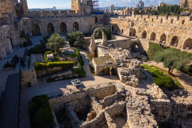 Kudüs 'te yeşil ağaçlarla çevrili kemerli geçitleri ve kuleleri olan tarihi sarayın resimli manzarası.