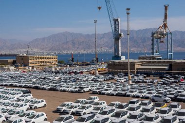 Eilat, İsrail - 25 Kasım 2022: İsrail 'de satılmak üzere asfalt yolda park etmiş birçok modern beyaz arabanın yüksek açısı