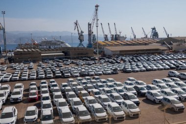 Eilat, İsrail - 25 Kasım 2022: İsrail 'de satılmak üzere asfalt yolda park etmiş birçok modern beyaz arabanın yüksek açısı