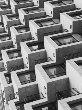 Gündüz vakti kare şeklindeki pencereleri ve balkonları olan modern geometrik konut binasının siyah ve beyazından