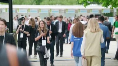 Moskova - 6 Haziran 2023: İş etkinliği sırasında kalabalık caddelerde boyunluk rozeti takan pek çok kişinin gerçek zamanı