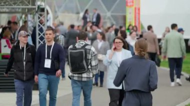 Moskova - 6 Haziran 2023: Rozetleri ve kameraları olan meşgul insanların festival hazırlıkları sırasında sahne kenarında yürüdükleri gerçek zamanlı