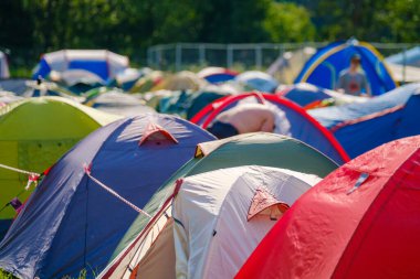 Güneşli yaz gününde festival sırasında kamp alanındaki renkli kamp çadırları kuruldu.