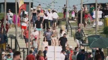 Moskova - 16 Haziran 2023: Festivalde güneşli bir gün geçirirken, yaz kıyafetleriyle merdivenlerde yürüyen insanların gerçek zamanlı fotoğrafları