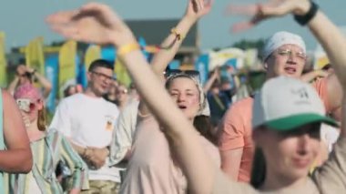 Moskova - 16 Haziran 2023: Kaygısız insanların yaz festivalinde toplandığı ve güneşli bir günde dans ederken şarkı söylediği gerçek bir zaman