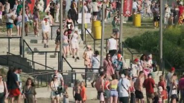 Moskova - 16 Haziran 2023: Festivalde güneşli bir gün geçirirken, yaz kıyafetleriyle merdivenlerde yürüyen insanların gerçek zamanlı fotoğrafları