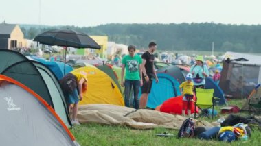 Moskova - 16 Haziran 2023: Gezginlerin yaz tatilini kırsalda geçirdikleri festival sırasında çimenli zeminde çadır kurdukları gerçek zamanlı fotoğraf