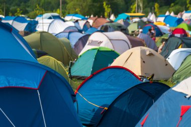 Güneşli bir günde müzik festivali sırasında kamp alanında renkli çadırlar kuruldu.