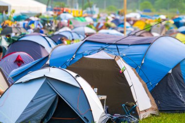 Güneşli bir günde müzik festivali sırasında kamp alanında renkli çadırlar kuruldu.