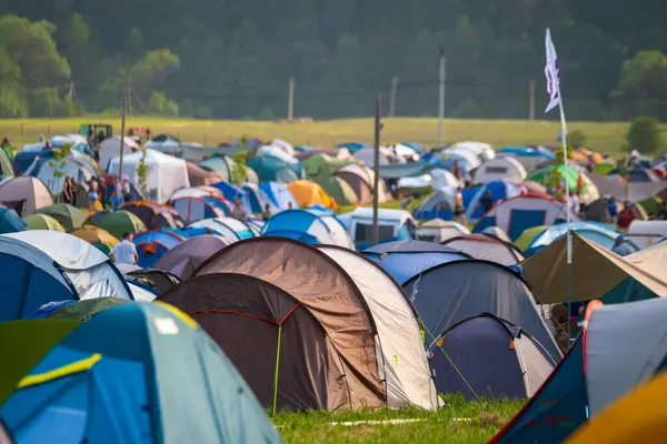Güneşli bir günde müzik festivali sırasında kamp alanında renkli çadırlar kuruldu.