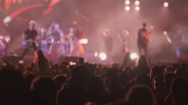 Müzik grubunun konserinde gerçek zamanlı hayranlar. Şarkıcının son şarkısı ve neon ışıklarıyla sahne yayını yapıyor.