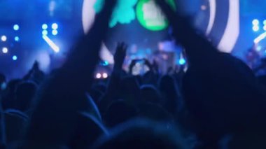 İnsanların siluetlerinin gerçek zamanına dönüp kollarını salladığı ve bando müziğiyle birlikte dans ettiği gece aydınlık sahnede performans sergileyen