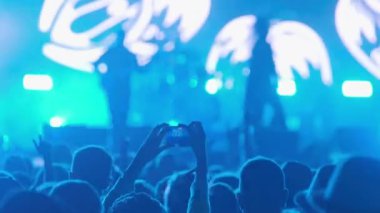 Performans videosu çeken kişinin müzik grubu gösterilerinde seyirci kalabalığı arasında görüntüsü