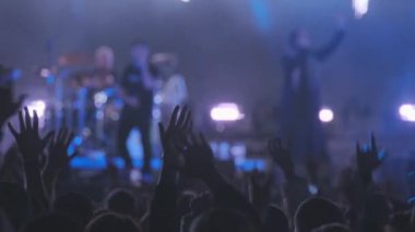 Müzik grubunun performansını dinlerken heyecanlanan ve kollarını kaldıran hayranların el kamerası görüntüleri.