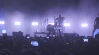 Davulcu ve gitaristli bir müzik grubu sahne alıyor. Parlayan ışıklarla şarkıya başlıyor.
