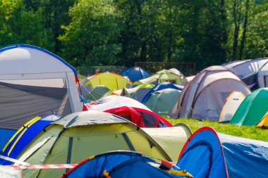Güneşli bir günde müzik festivali sırasında kamp alanında renkli çadırlar kuruldu.
