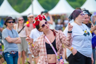 Moskova - 13 Haziran 2023: Kamp alanındaki konserde çalan müzik eşliğinde çiçeklerle dans eden kadın