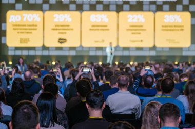 Moskova, 30 Kasım 2023: Projeksiyon ekranında yer alan sayı verileriyle küresel atölyeye katılan çeşitli iş çevreleri 