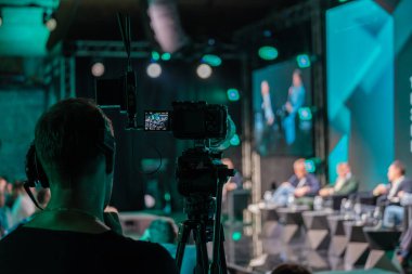 İş konferansı sırasında sahnedeki hoparlörleri kaydeden profesyonel video kameraların yakın çekimi. Canlı etkinlik çekimlerinde teknoloji ve iletişim üzerine odaklanın.
