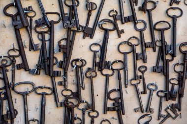 Eski tasarım ve tarihin sergilendiği kırsal yüzeye dağılmış eski demir anahtarlar. Nostalji, güvenlik ve miras kavramları için mükemmel..