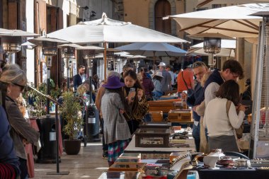 Arezzo, Italy - November 2, 2024: Visitors browse antiques at the monthly market in Arezzo historic center, exploring items displayed by vendors along the streets and squares clipart