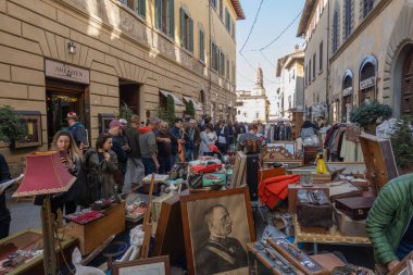 Arezzo, İtalya - 2 Kasım 2024: Ziyaretçiler, Arezzo tarihi merkezindeki aylık pazarda, sokak ve meydanlar boyunca satıcıların sergilediği eşyaları araştırarak antikalara göz atıyor