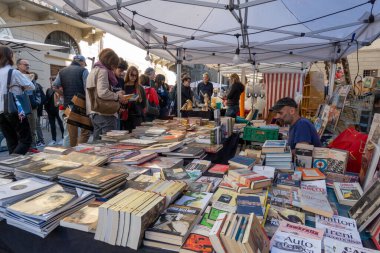 Arezzo, İtalya - 2 Kasım 2024: Ziyaretçiler, Arezzo tarihi merkezindeki aylık pazarda, sokak ve meydanlar boyunca satıcıların sergilediği eşyaları araştırarak antikalara göz atıyor