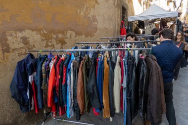 Arezzo, İtalya - 2 Kasım 2024: Ziyaretçiler, Arezzo tarihi merkezindeki aylık pazarda, sokak ve meydanlar boyunca satıcıların sergilediği eşyaları araştırarak antikalara göz atıyor