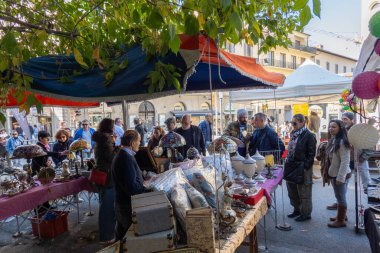 Arezzo, İtalya - 2 Kasım 2024: Ziyaretçiler, Arezzo tarihi merkezindeki aylık pazarda, sokak ve meydanlar boyunca satıcıların sergilediği eşyaları araştırarak antikalara göz atıyor