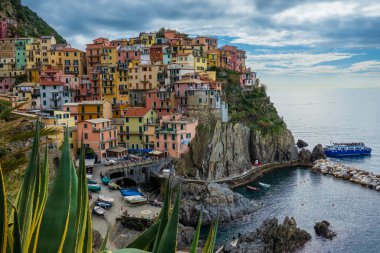 Canlı binalar Cinque Terre 'de okyanus kıyısında kayalıklarda oturur ve resim gibi bir manzara sunar. Manzara, bu İtalyan sahil köyünün cazibesini ön plana çıkaran kıyı şeridi yakınlarındaki bir tekneyi de içeriyor..