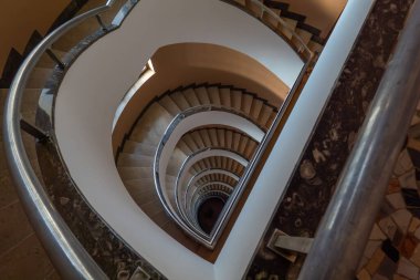 Dizzying spiral staircase view captures elegant curves and architectural beauty within building. clipart