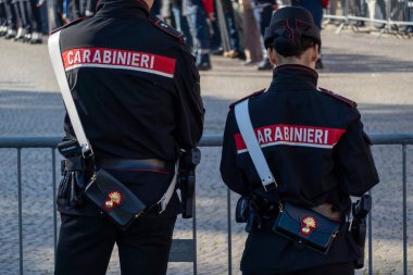 İki jandarma subayı bir bariyerin yanında duruyor, İtalya 'daki bir halk toplantısında güvenliği sağlıyorlar..