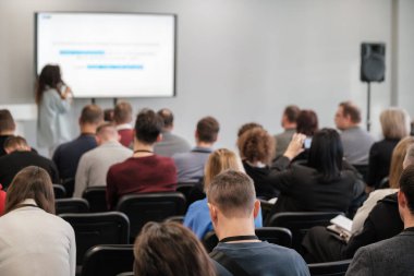 İş konferansında sunum yapan bir grup profesyonel. Konuşmacı özenli dinleyicilere konuşma yapıyor. Katılımcılar öğrenme ve ağ oluşturma.