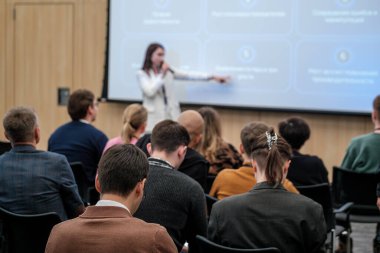İş adamları bir seminer sırasında konuşmacıların görüşlerine odaklanarak kurumsal bir sunum yapıyorlar..